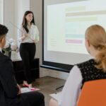 A young professional presenting data in a modern office to attentive colleagues.