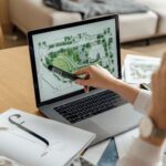 Architect reviewing landscape design on laptop, enhancing architectural projects from home office.