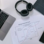 Flat lay of a modern workspace with tech gadgets and a startup financing cycle chart.