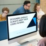 Group of designers collaborating in modern office space with computer.