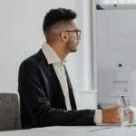 Professional male analyzing growth chart during modern office meeting session.