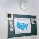 A planning board with a USA tech startup map and sticky notes next to a wall clock.