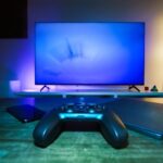 A stylish and ambient gaming setup featuring a controller, smart devices, and a TV in a lit living room.