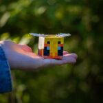 Close-up of a hand holding a Minecraft-inspired papercraft figurine outdoors.
