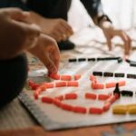 Players engage in a strategic board game, enhancing focus and teamwork indoors.